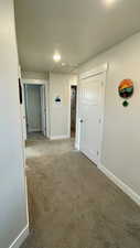 Hall with baseboards and carpet flooring