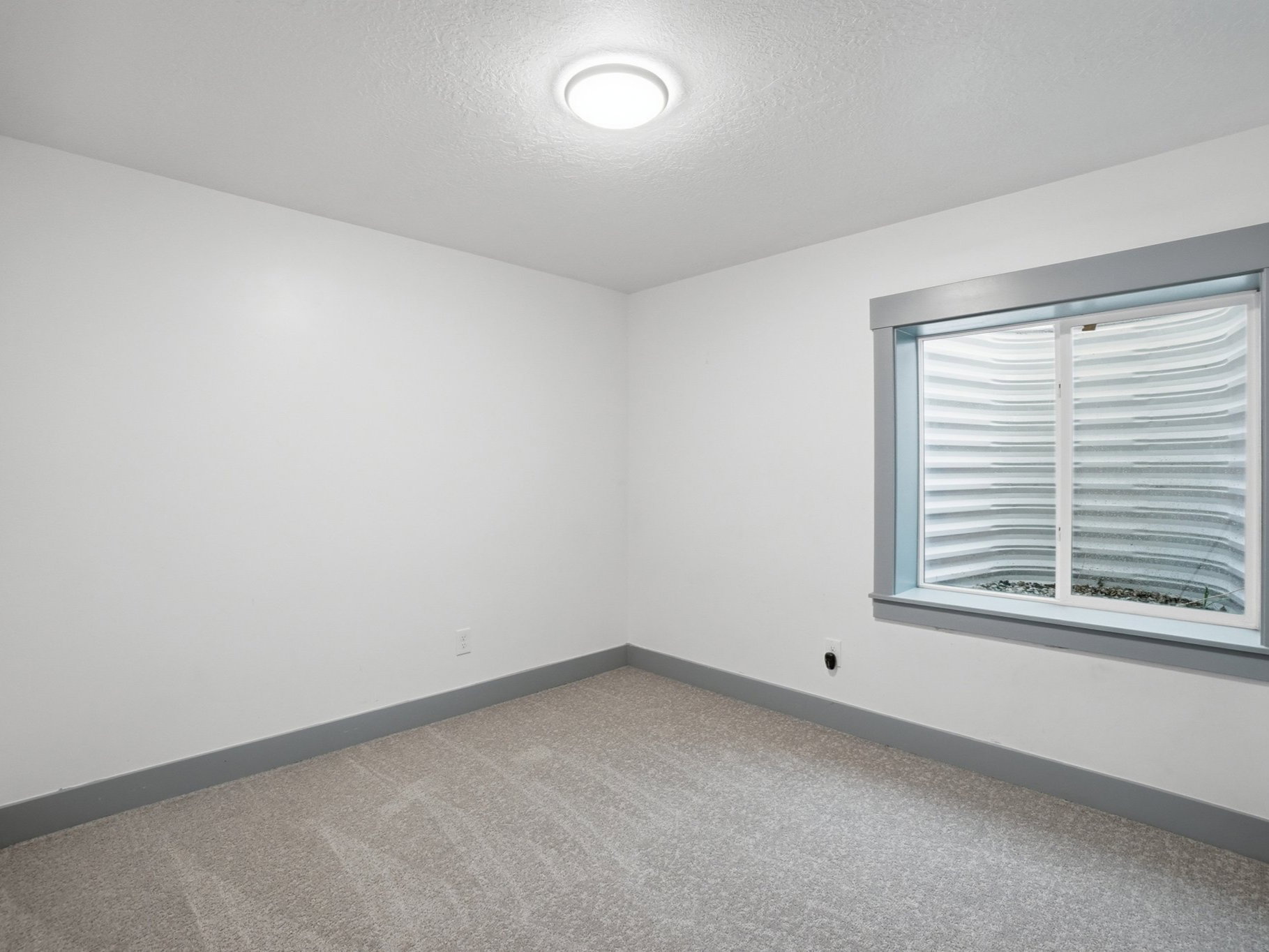 Carpeted spare room with baseboards and a textured ceiling
