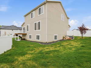 Back of house featuring a fenced backyard, a wooden deck, and stucco siding