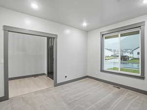 Empty room featuring light colored carpet and a water view