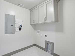 Laundry room with electric panel, hookup for an electric dryer, cabinet space, and hookup for a washing machine