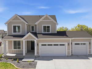 Craftsman-style house featuring roof with shingles, covered porch, and concrete driveway