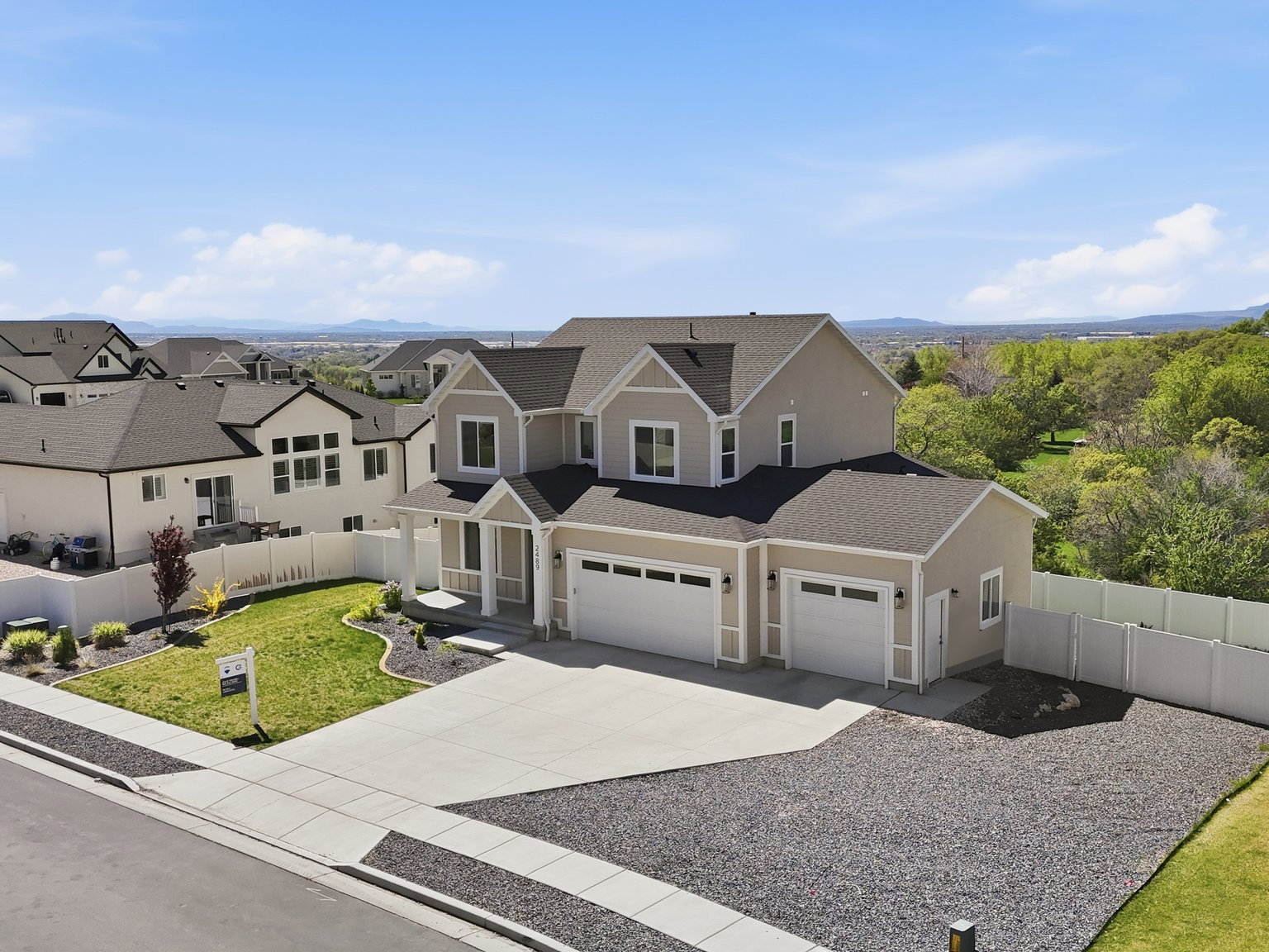 View of front of property with driveway, roof with shingles, and a residential view