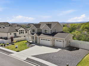 View of front of property with driveway, roof with shingles, and a residential view