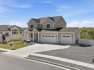View of front of house with driveway, a garage, and a shingled roof