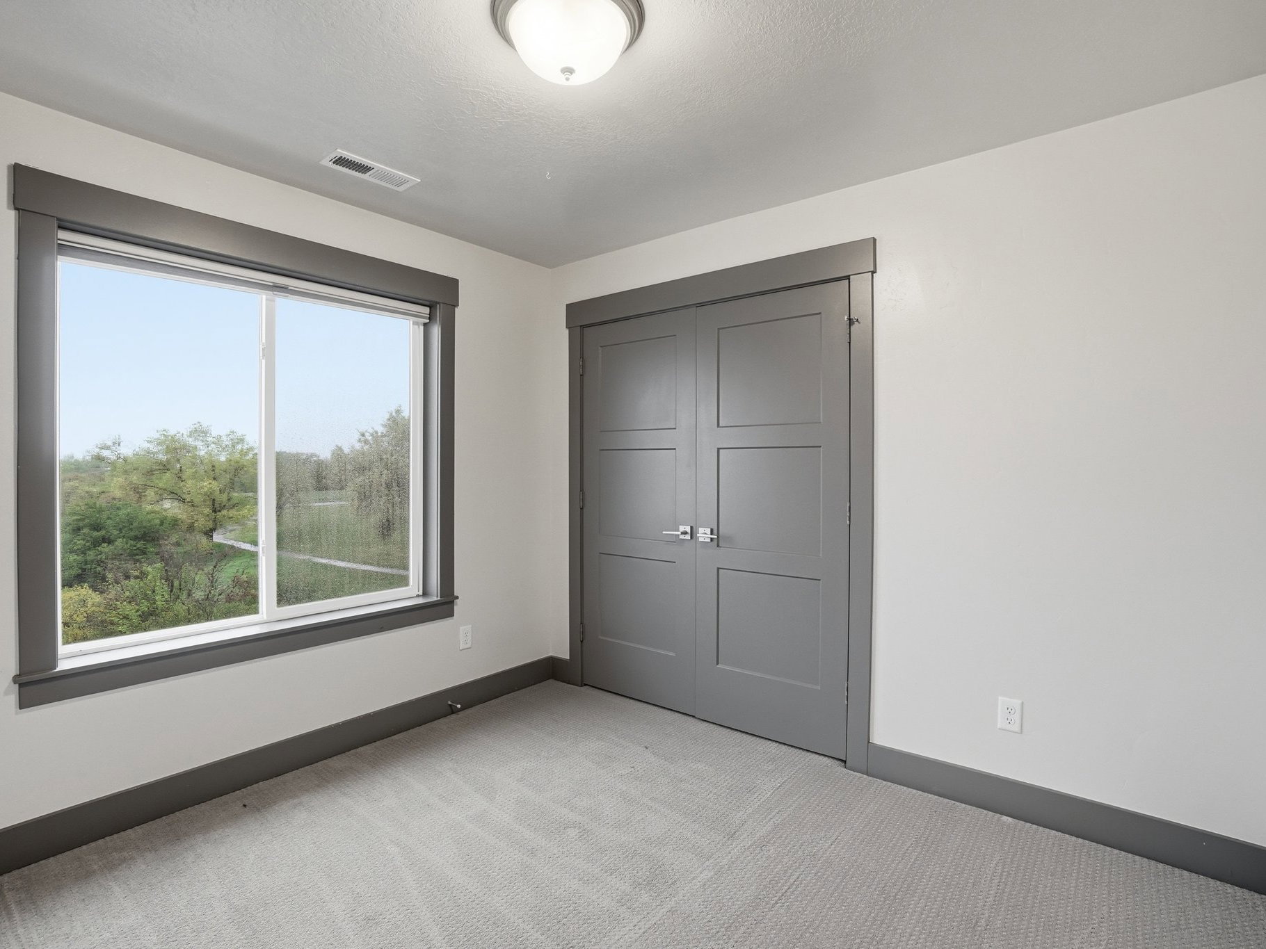 Unfurnished bedroom with light colored carpet and a closet