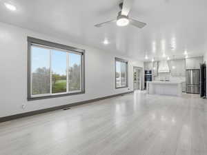 Unfurnished living room with a ceiling fan, light wood-type flooring, and recessed lighting