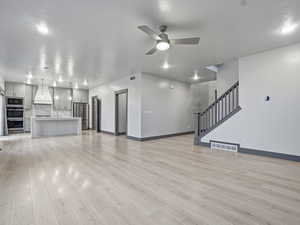 Unfurnished living room with a ceiling fan, light wood-style floors, and recessed lighting