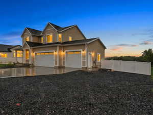 View of front of home with concrete driveway, an attached garage, and a garage