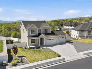 View of front of house featuring driveway, an attached garage, a mountain view, a residential view, and a porch