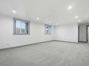 Empty room with light carpet and recessed lighting