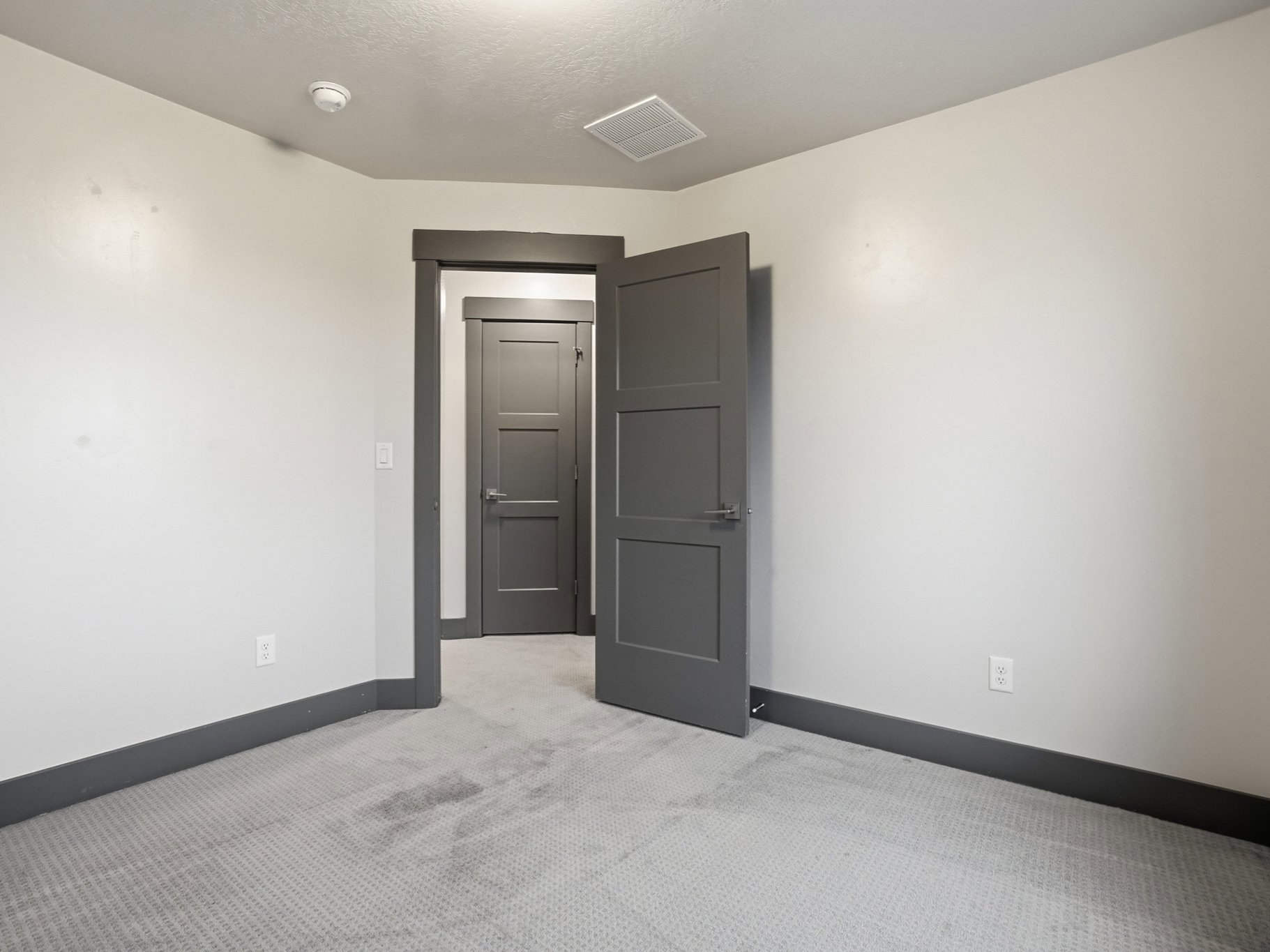 Spare room featuring light carpet and baseboards