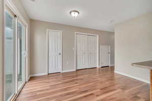 Unfurnished dining area with light wood-style flooring and baseboards