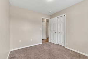 Unfurnished bedroom with carpet and a closet