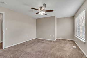 Spare room featuring carpet flooring, a ceiling fan, and a smoke detector