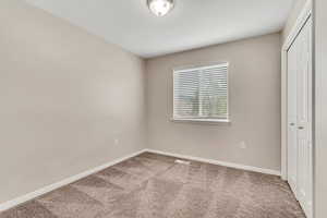 Unfurnished bedroom featuring a closet and carpet flooring