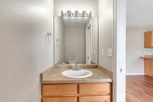 Half bath featuring vanity and wood finished floors