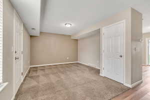 Below grade area featuring baseboards and light colored carpet