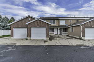 Traditional-style home featuring a garage, driveway, and brick siding