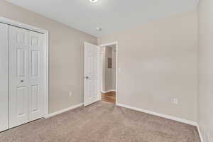Unfurnished bedroom with a closet and light colored carpet