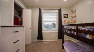 Bedroom with a closet and light colored carpet