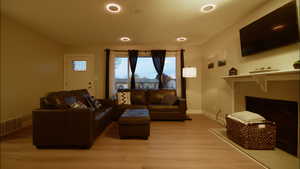 Living room featuring light wood-type flooring and a fireplace