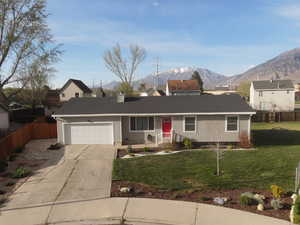 View of front of house featuring driveway, a garage, a mountain view, and roof with shingles