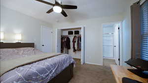 Bedroom with light colored carpet, ceiling fan, a closet, and ensuite bathroom