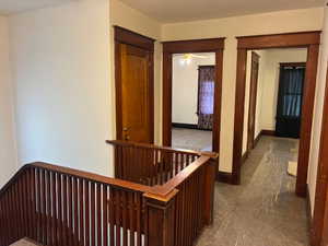 Hall featuring an upstairs landing and carpet flooring