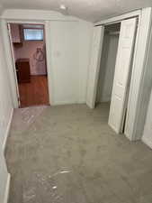 Unfurnished bedroom with a textured ceiling, carpet floors, and a closet
