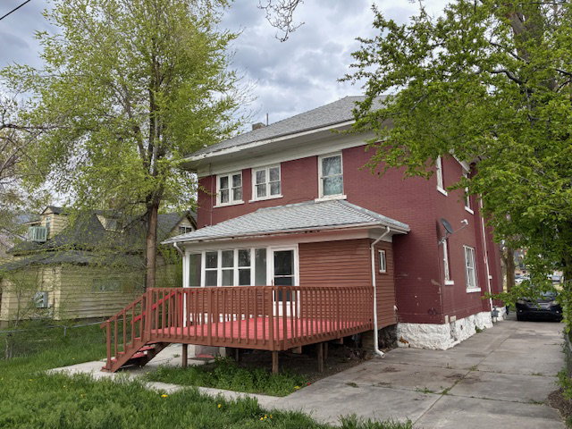 Back of property featuring a wooden deck and a shingled roof