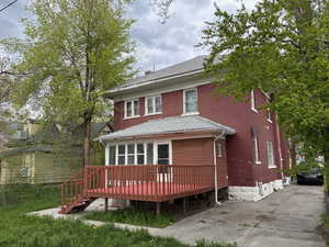 Back of property featuring a wooden deck and a shingled roof