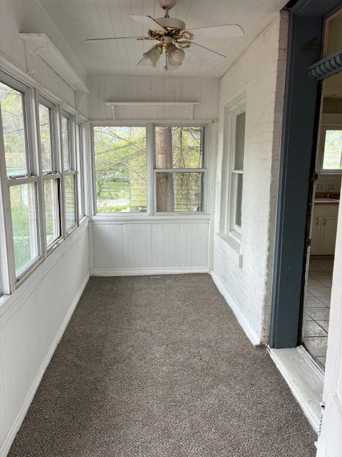Unfurnished sunroom with a ceiling fan