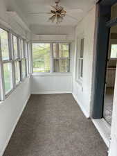 Unfurnished sunroom with a ceiling fan