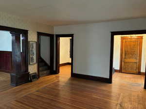 Unfurnished living room with hardwood / wood-style flooring and baseboards