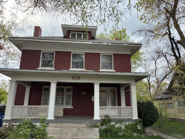 Traditional style home featuring a chimney and a porch