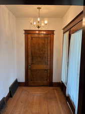 Foyer with hardwood / wood-style flooring and a chandelier