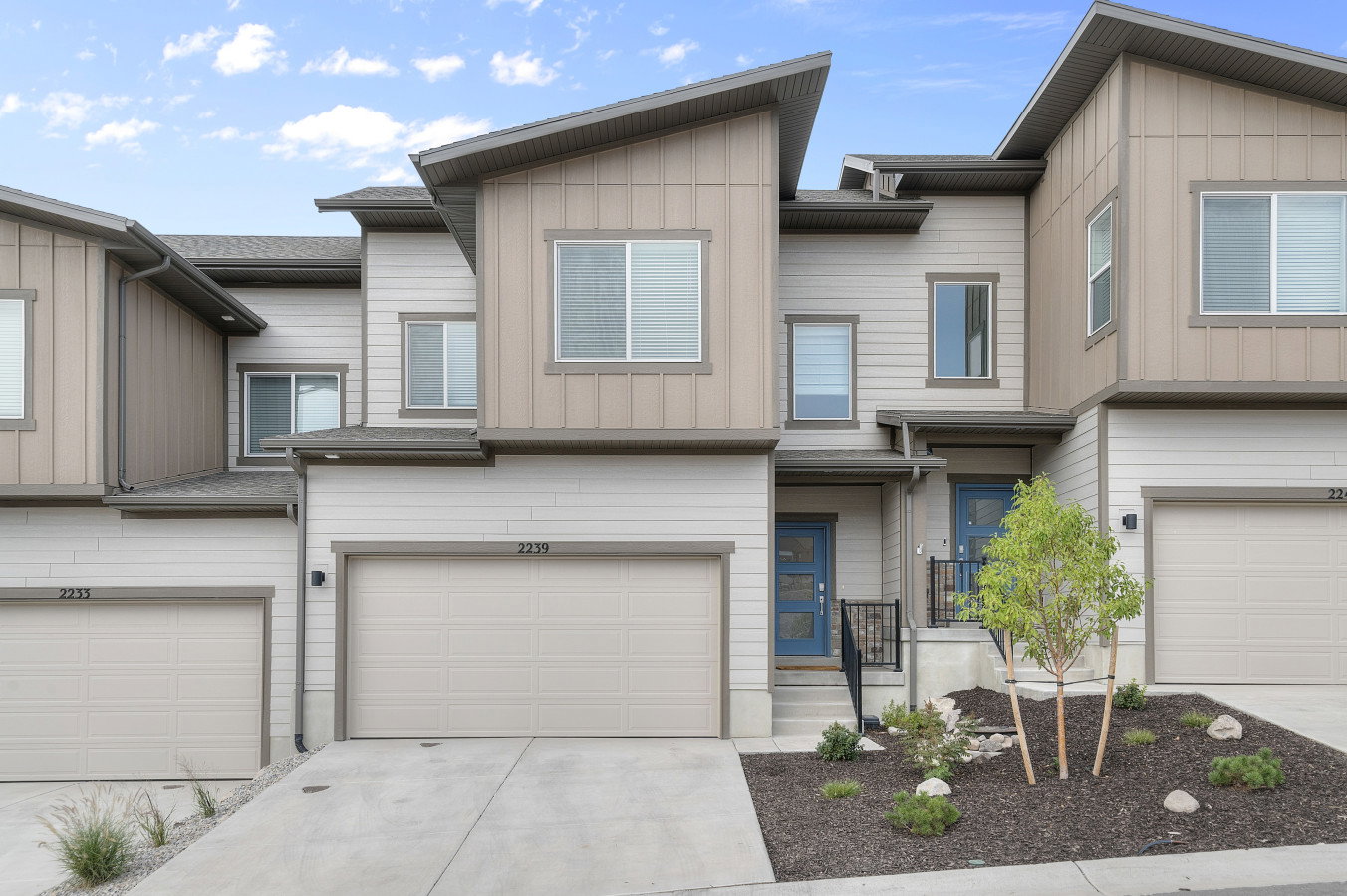 Welcome home! View of the front facade with an attached 2 garage, driveway, and board and batten siding