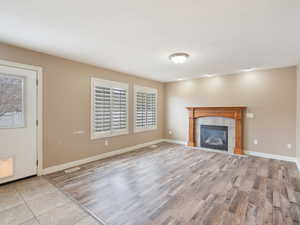 Unfurnished living room with light wood-style flooring and a tile fireplace