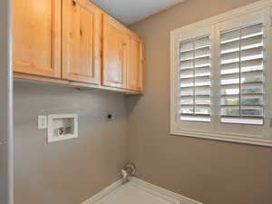 Laundry room featuring hookup for a washing machine, electric dryer hookup, and cabinet space