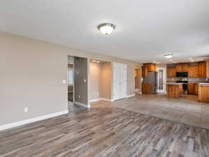 Unfurnished living room with light wood-style floors and baseboards