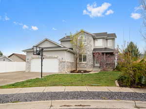 Traditional-style house featuring driveway, a front lawn, a garage, and stucco siding