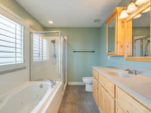 Full bathroom with vanity, a shower stall, a whirlpool tub, and recessed lighting