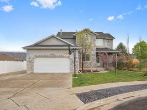 View of front facade featuring driveway, a garage, stucco siding, and covered porch