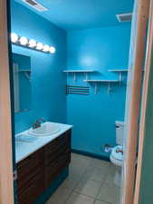 Bathroom featuring vanity, light tile patterned flooring, and a textured ceiling