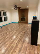 Unfurnished living room featuring wood finished floors and ceiling fan