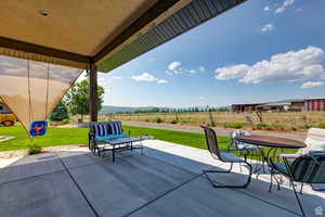 View of patio / terrace featuring a rural view, outdoor dining space, and a mountain view