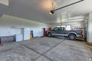 Garage with freestanding refrigerator and a garage door opener