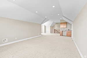 Additional living space with light colored carpet and recessed lighting