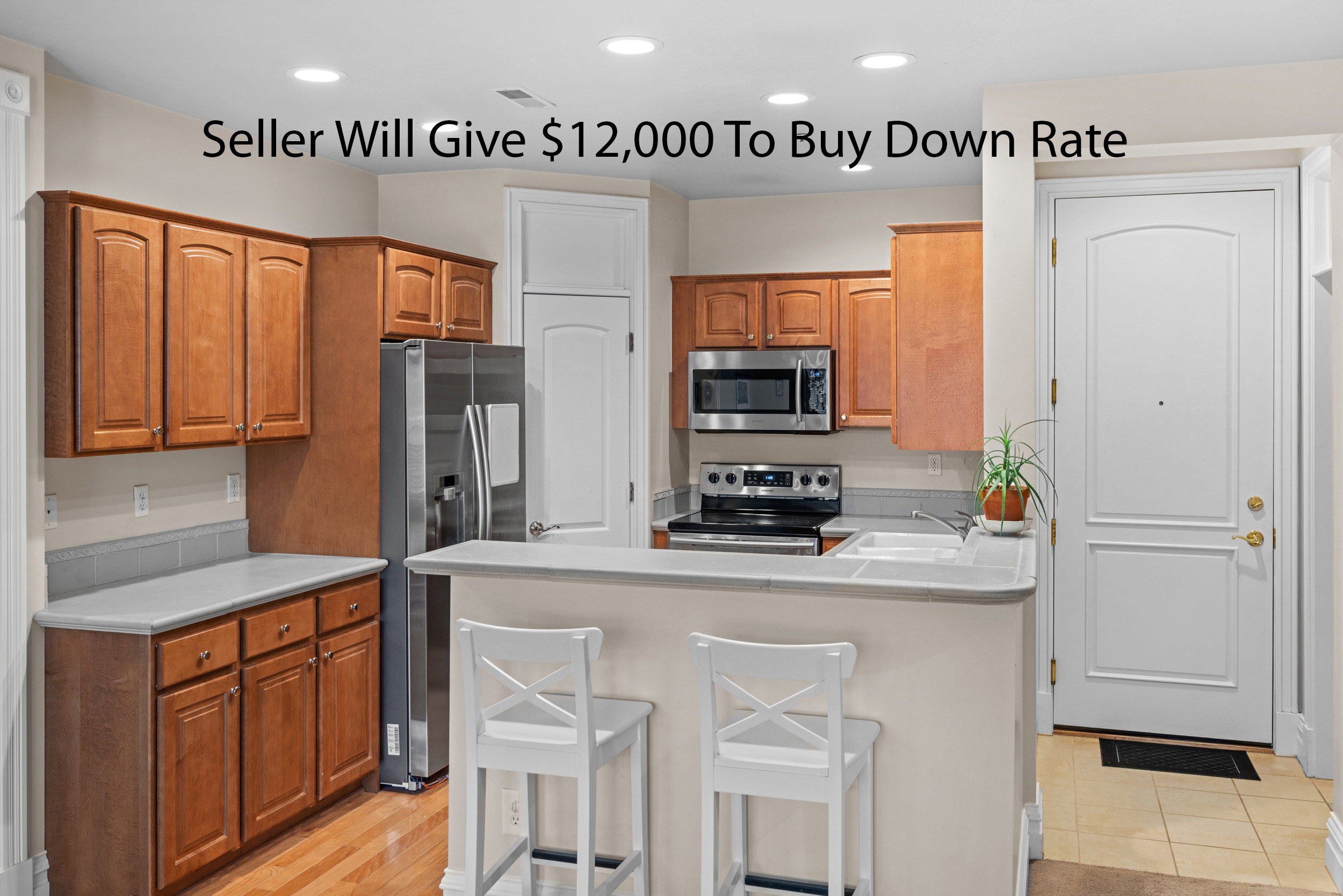 Kitchen featuring wood cabinetry, stainless steel appliances, a breakfast bar, recessed lighting, and a composite sink